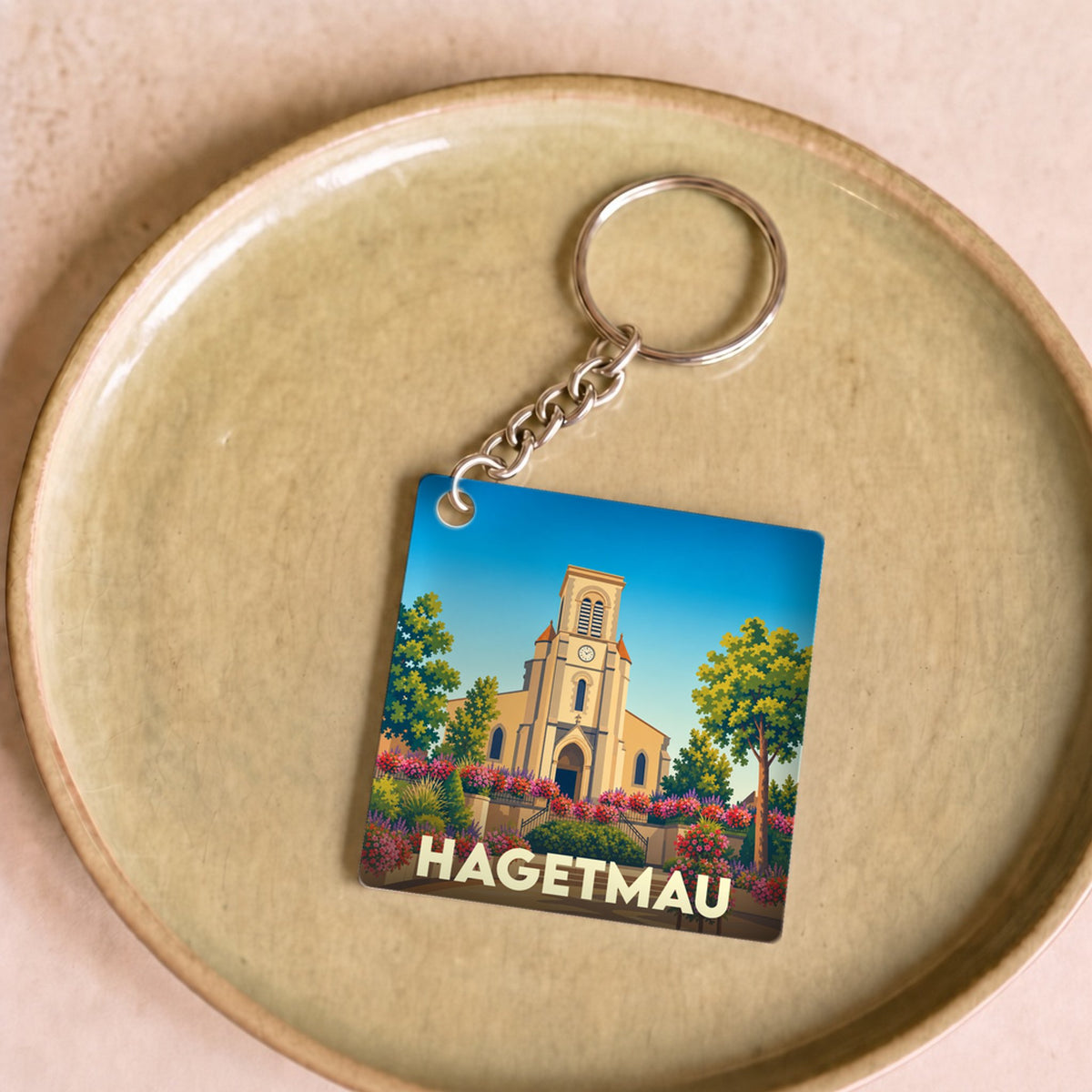 Porte-clés souvenir de la ville de Hagetmau avec une illustration stylisée de son église.