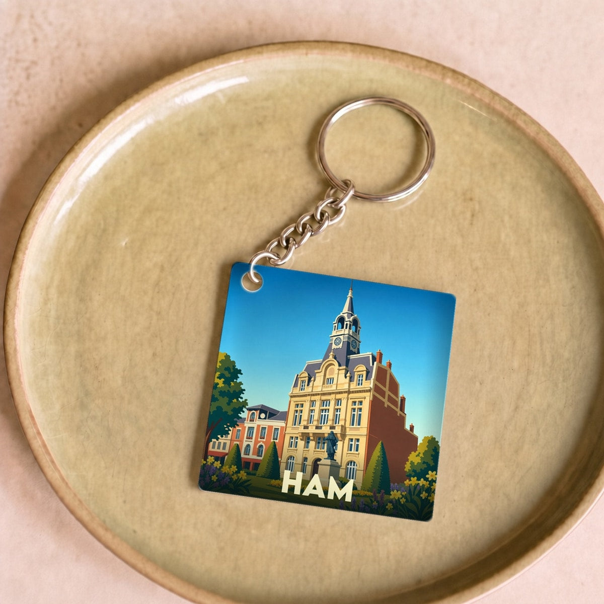 Porte-clés souvenir de la ville de Ham avec une illustration stylisée de son hôtel de ville.