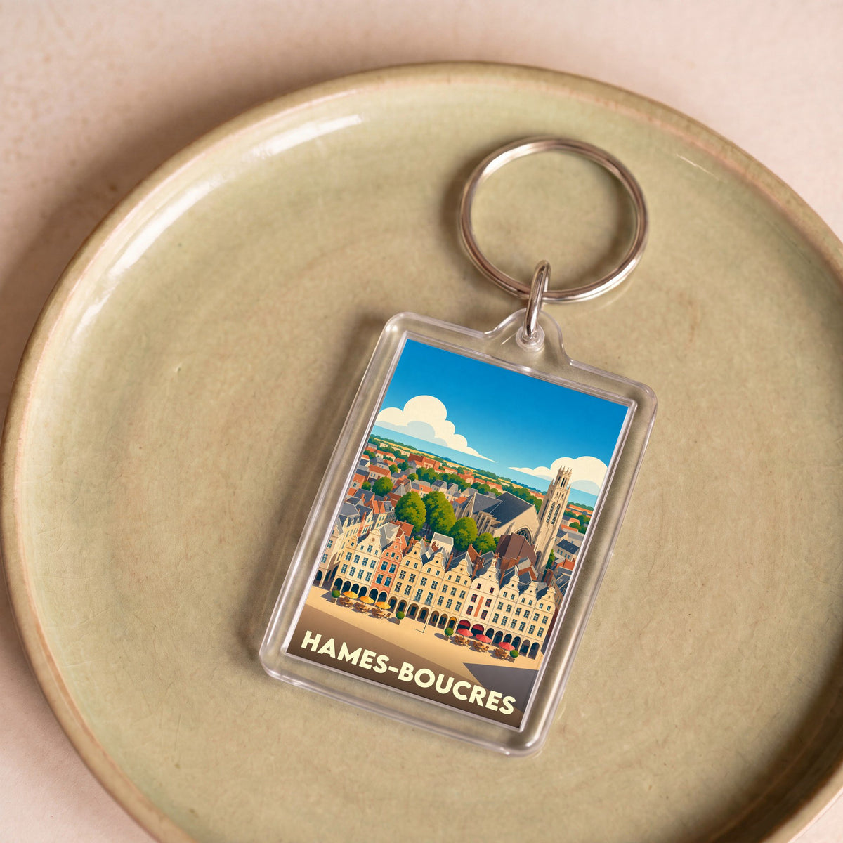 Porte-clés souvenir de la ville de Hames-Boucres avec une illustration stylisée.
