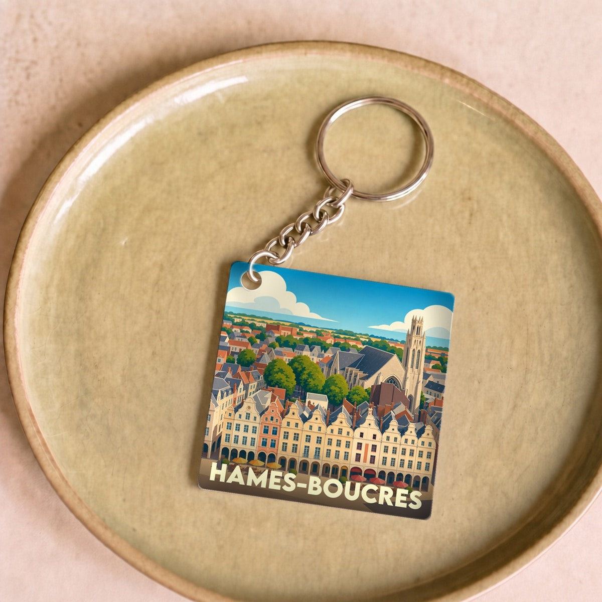 Porte-clés souvenir de la ville de Hames-Boucres avec une illustration stylisée.
