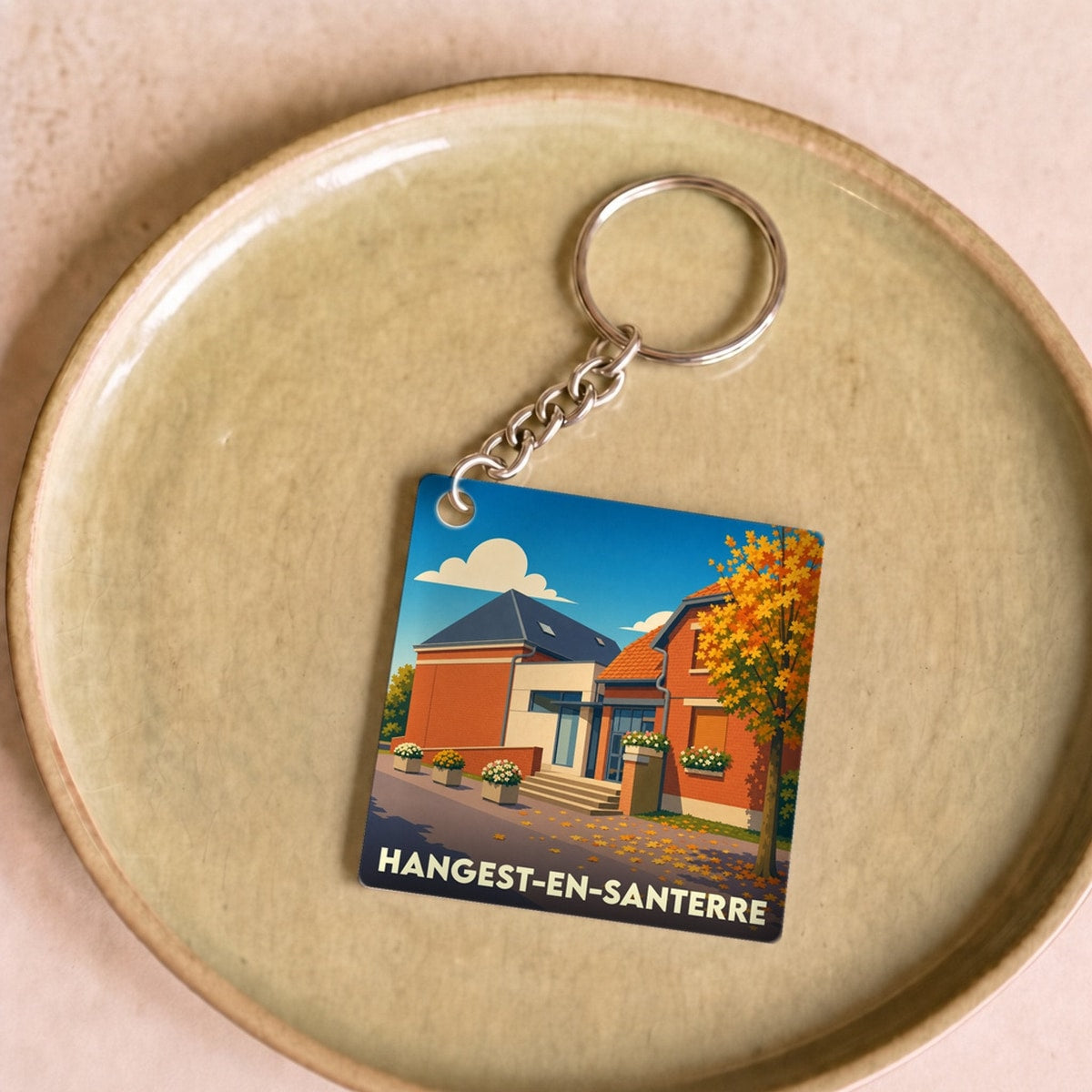 Porte-clés souvenir de la ville de Hangest-en-Santerre avec une illustration stylisée.