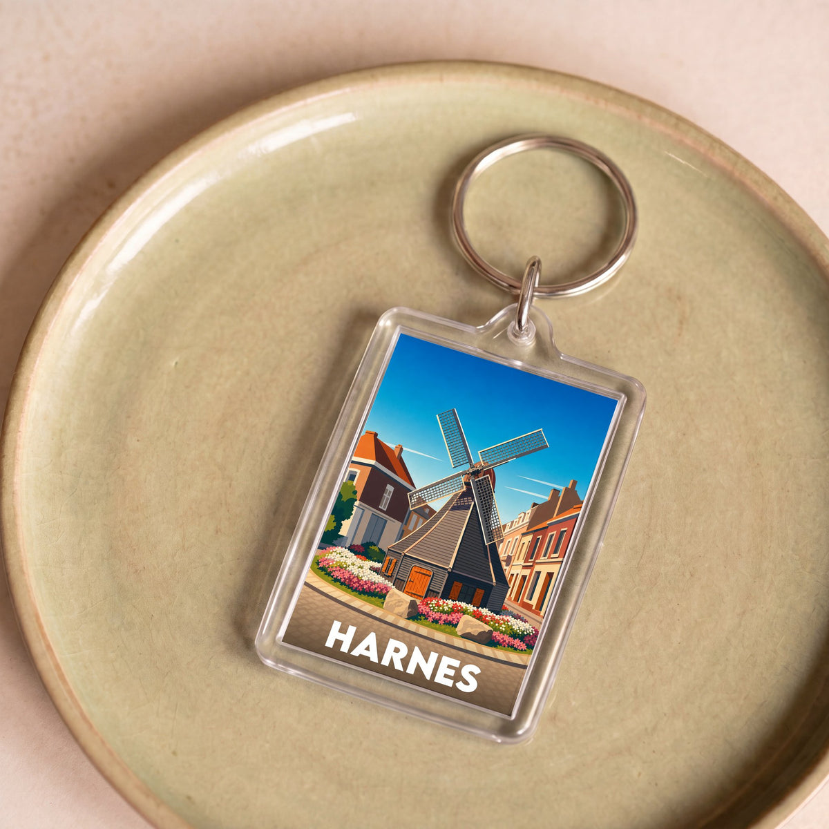 Porte-clés souvenir de la ville de Harnes avec une illustration stylisée.