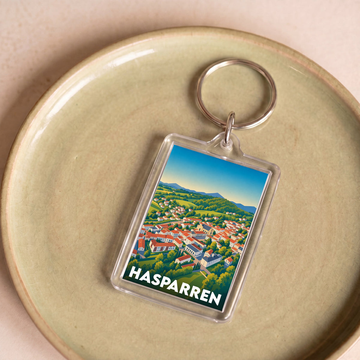 Porte-clés souvenir de la ville de Hasparren avec une illustration stylisée.