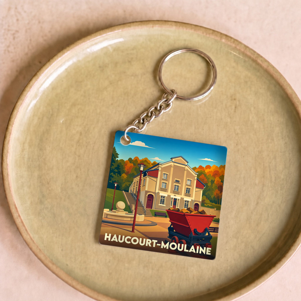 Porte-clés souvenir de la ville de Haucourt-Moulaine avec une illustration stylisée.