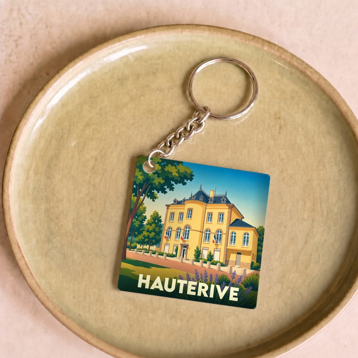 Porte-clés souvenir de la ville de Hauterive avec une illustration stylisée.