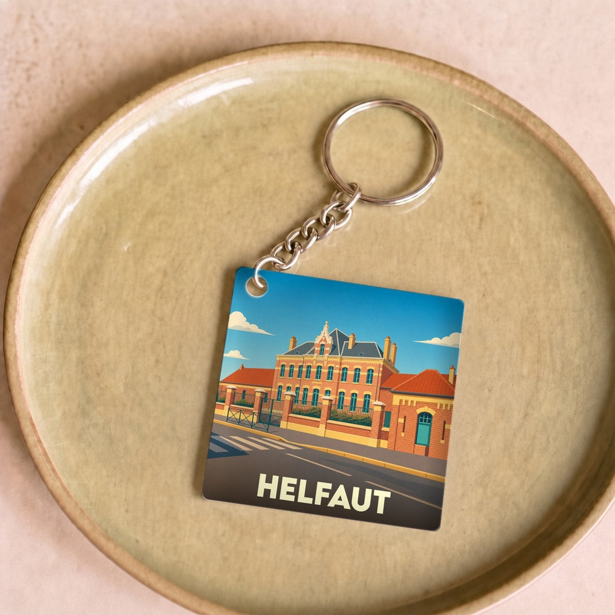 Porte-clés souvenir de la ville de Helfaut avec une illustration stylisée.