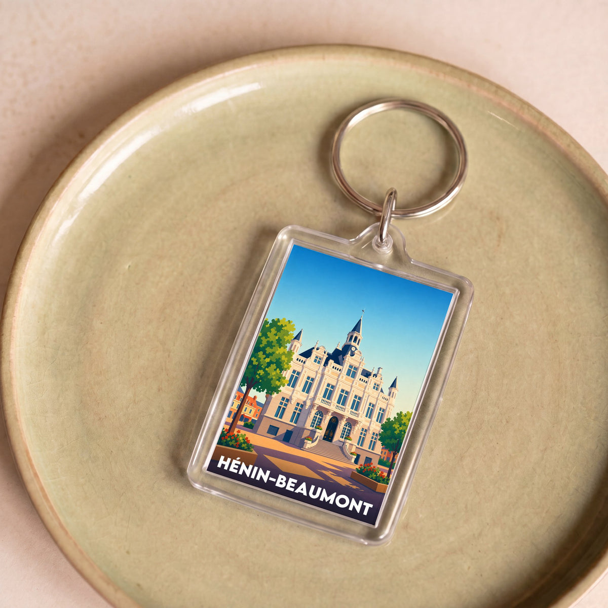 Porte-clés souvenir de la ville de Hénin-Beaumont avec une illustration stylisée.