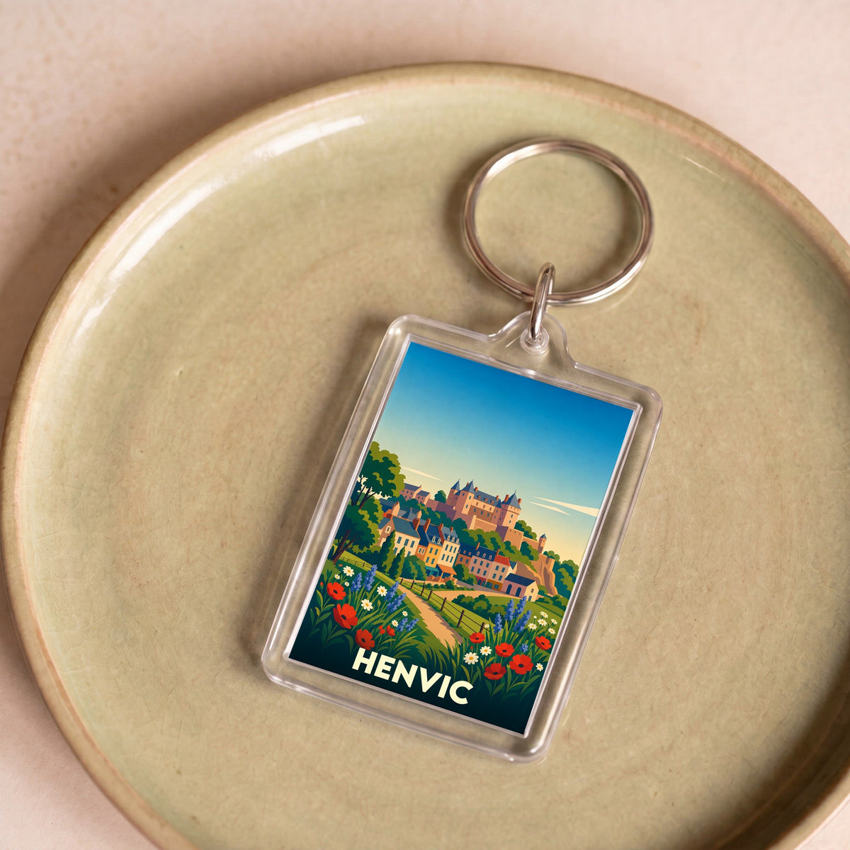 Porte-clés souvenir de la ville de Henvic avec une illustration stylisée et colorée.