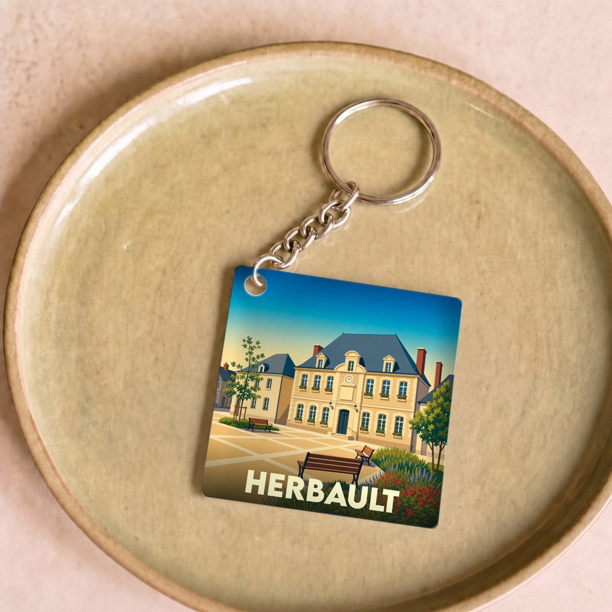 Porte-clés souvenir de la ville de Herbault avec une illustration stylisée.