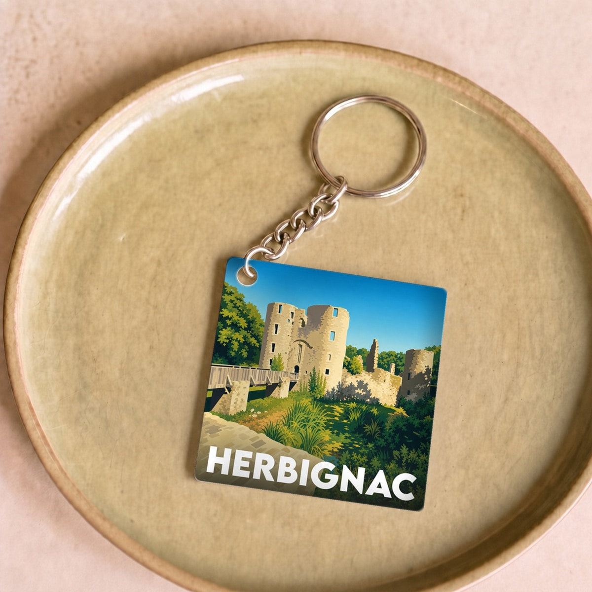 Porte-clés souvenir de la ville de Herbignac avec une illustration stylisée de son château.