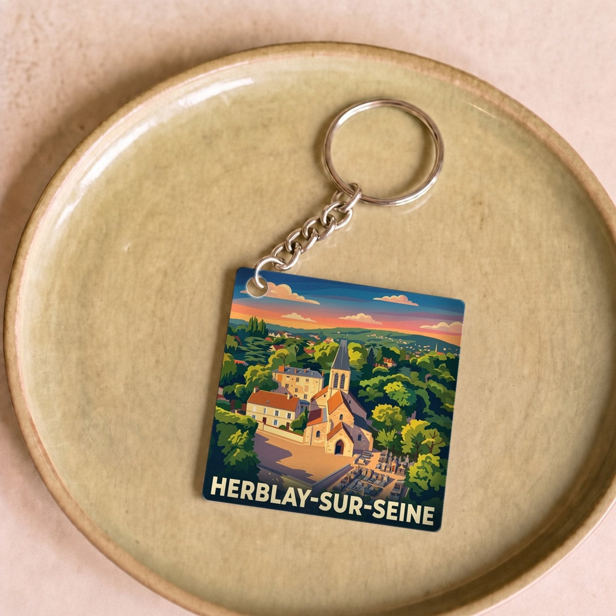 Porte-clés souvenir de la ville de Herblay-sur-Seine avec une illustration stylisée de son paysage.