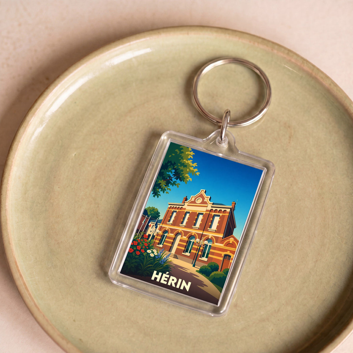 Porte-clés souvenir de la ville de Hérin avec une illustration stylisée de son hôtel de ville.