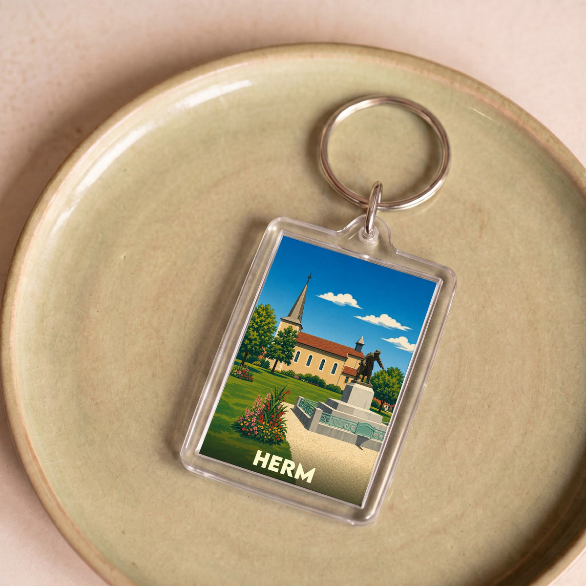Porte-clés souvenir de la ville de Herm avec une illustration stylisée.