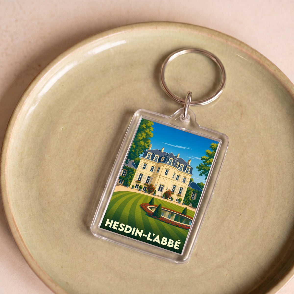 Porte-clés souvenir de la ville de Hesdin-l'Abbé avec une illustration stylisée de son patrimoine.