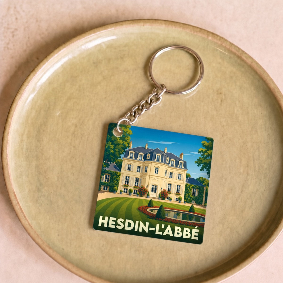 Porte-clés souvenir de la ville de Hesdin-l'Abbé avec une illustration stylisée de son patrimoine.