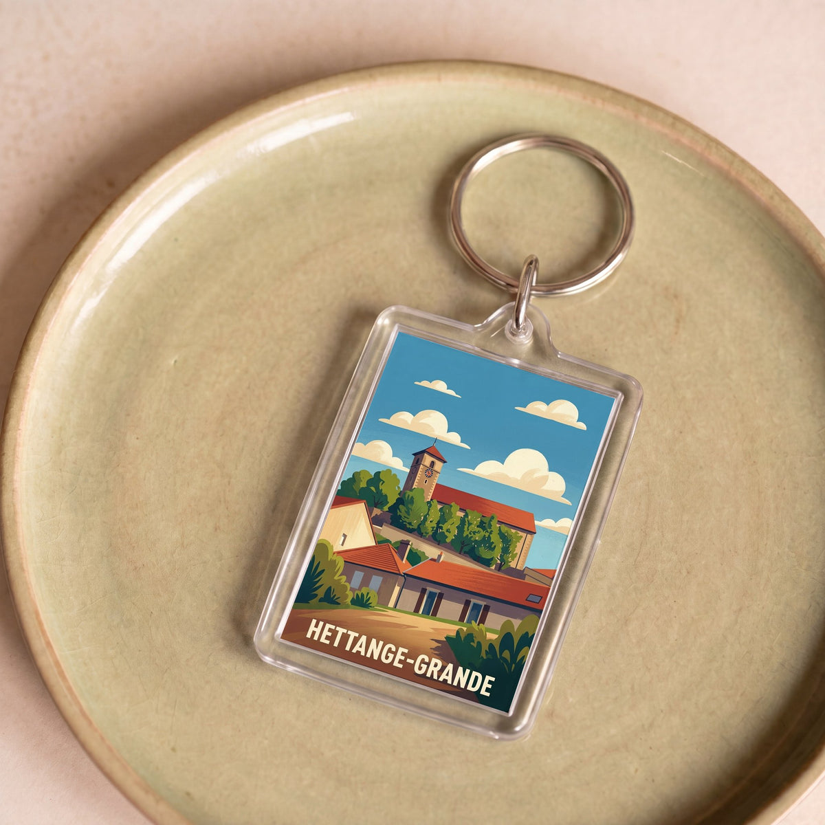 Porte-clés souvenir de la ville de Hettange-Grande avec une illustration stylisée.