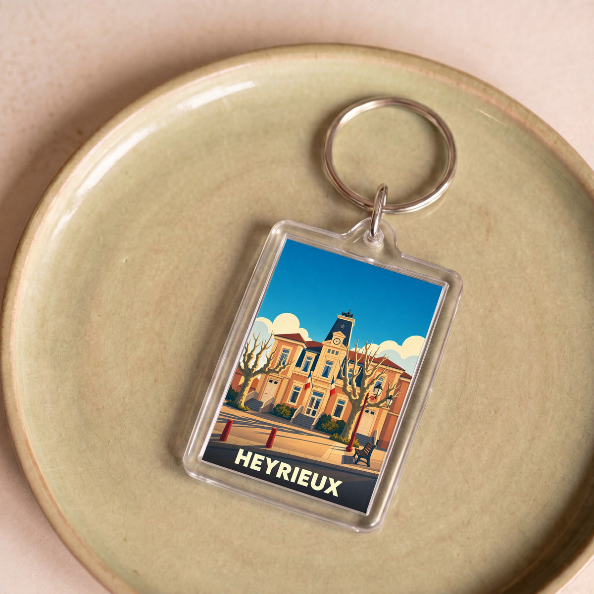Porte-clés souvenir de la ville de Heyrieux avec une illustration stylisée de son hôtel de ville.