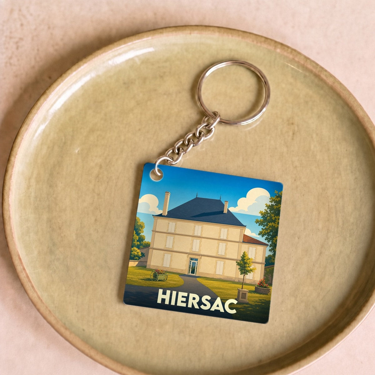 Porte-clés souvenir de la ville de Hiersac avec une illustration stylisée d'une demeure historique.