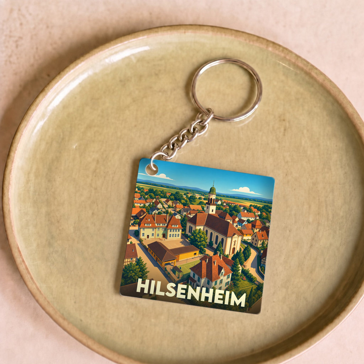 Porte-clés souvenir de la ville de Hilsenheim avec une illustration stylisée.
