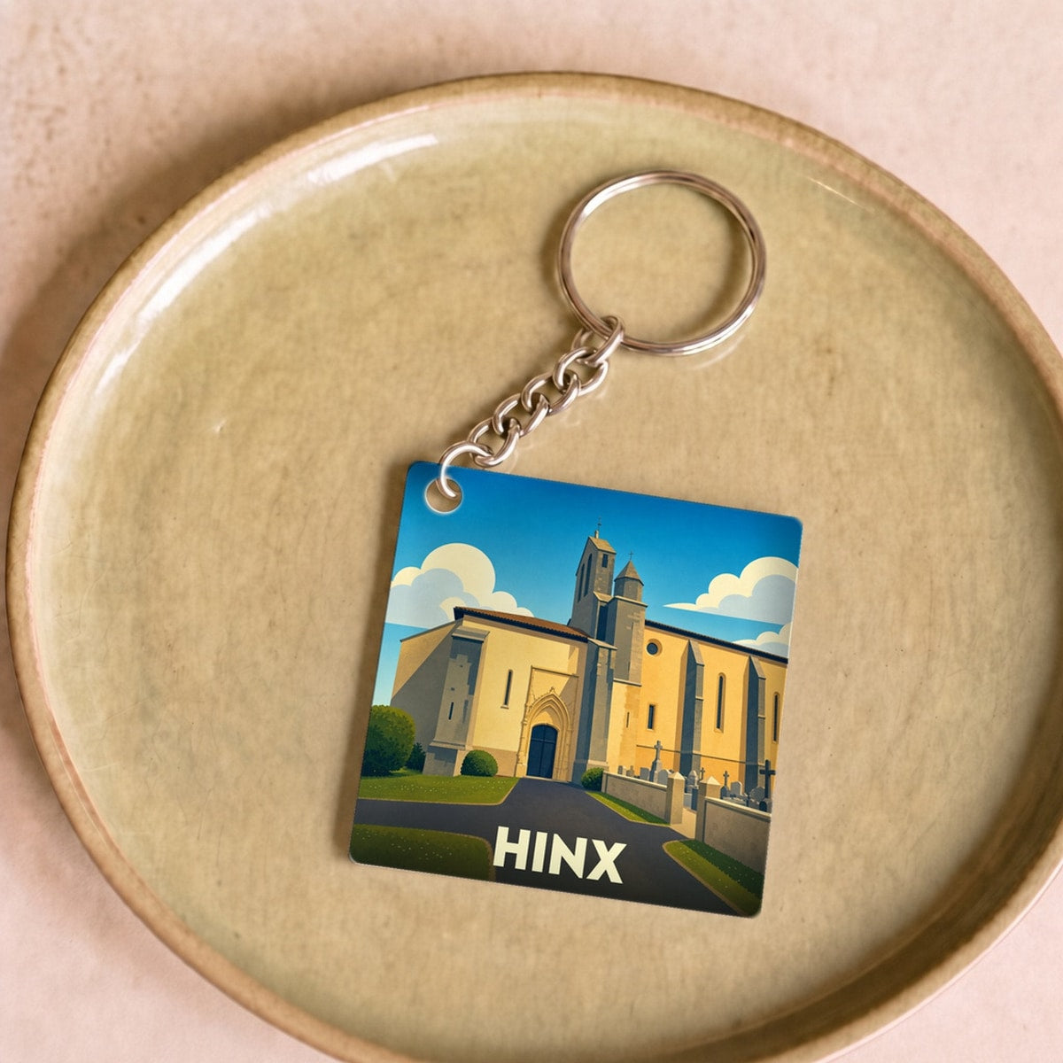 Porte-clés souvenir de la ville de Hinx avec une illustration stylisée de son église.
