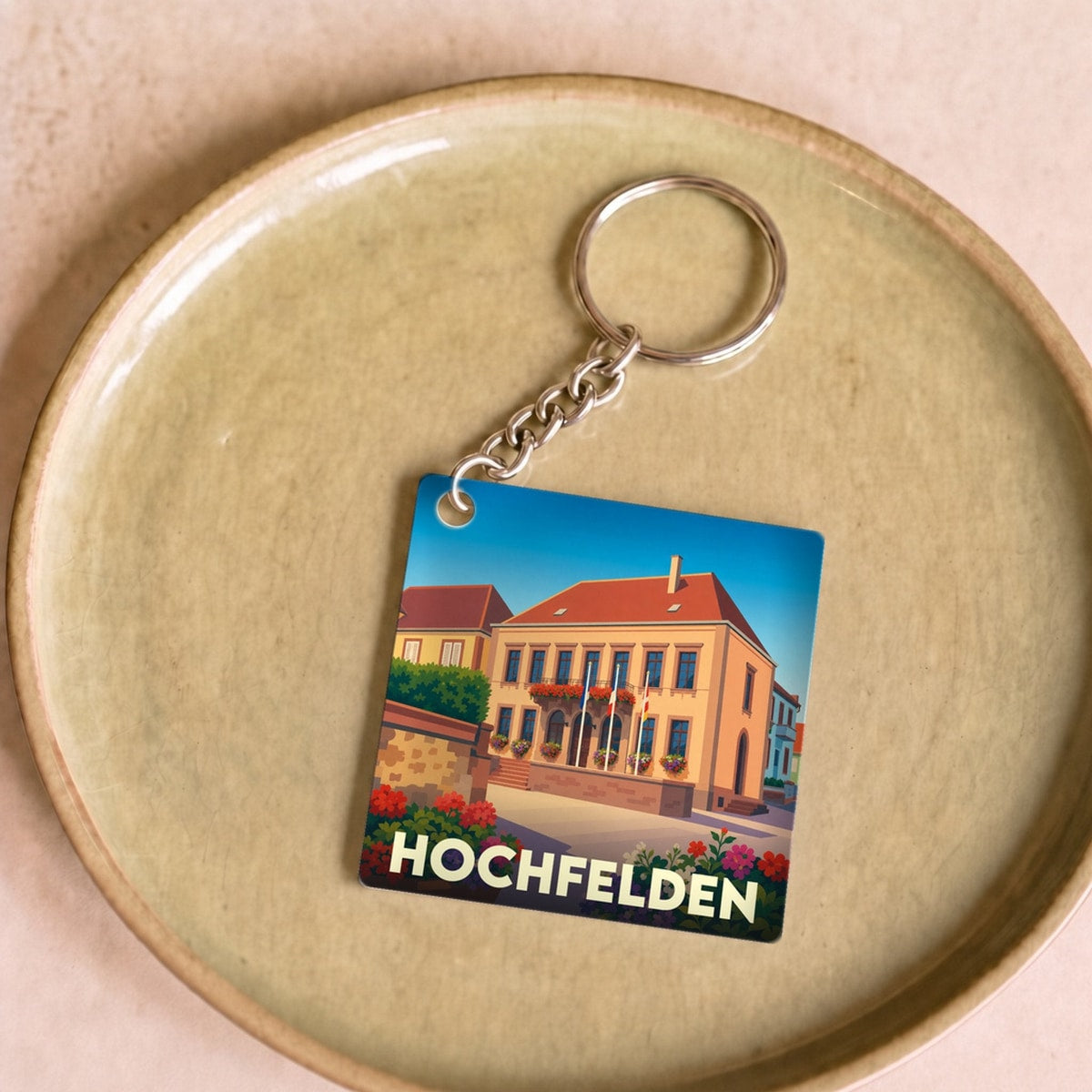 Porte-clés souvenir de la ville de Hochfelden avec une illustration stylisée de son hôtel de ville.