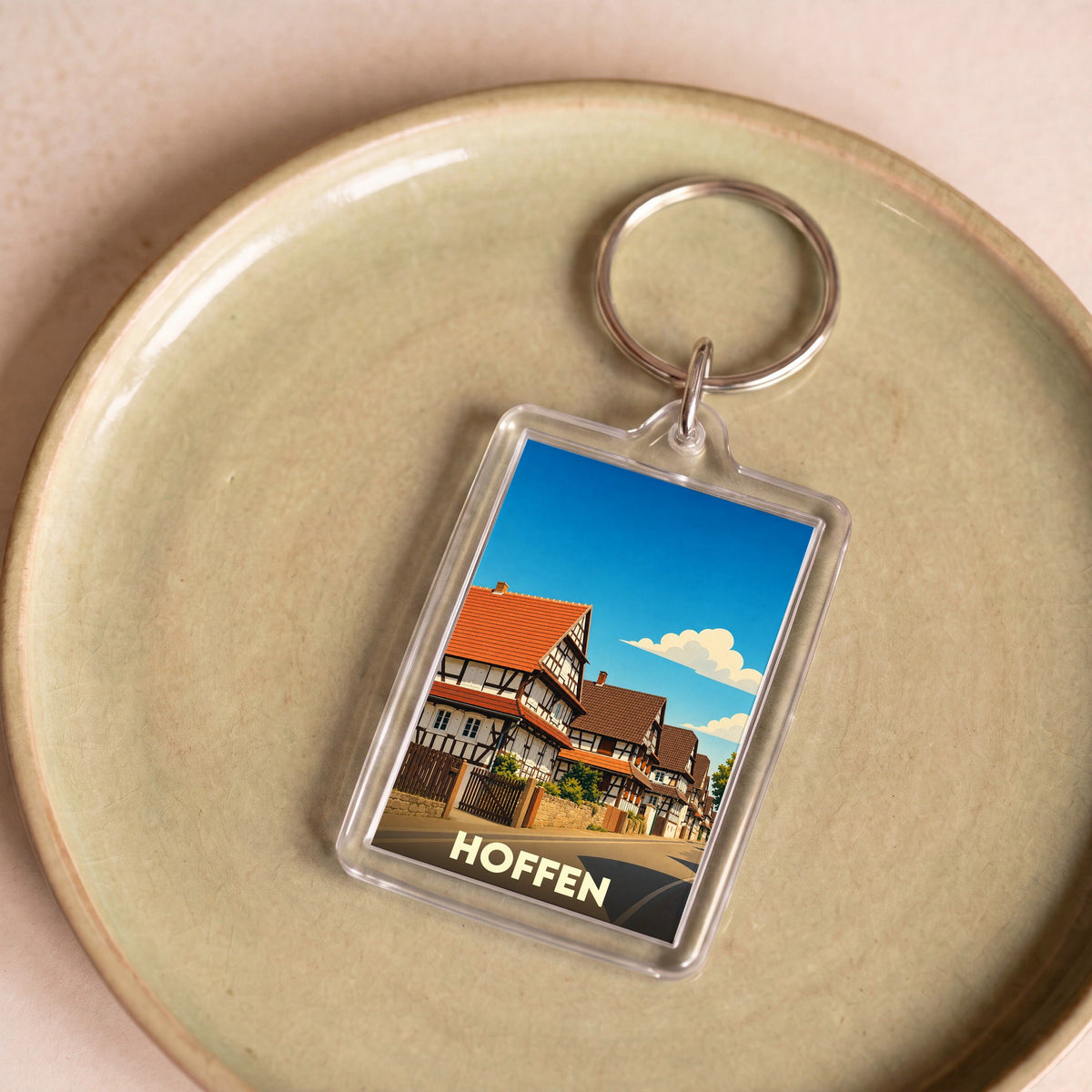 Porte-clés souvenir de la ville de Hoffen avec une illustration stylisée de maisons à colombages.