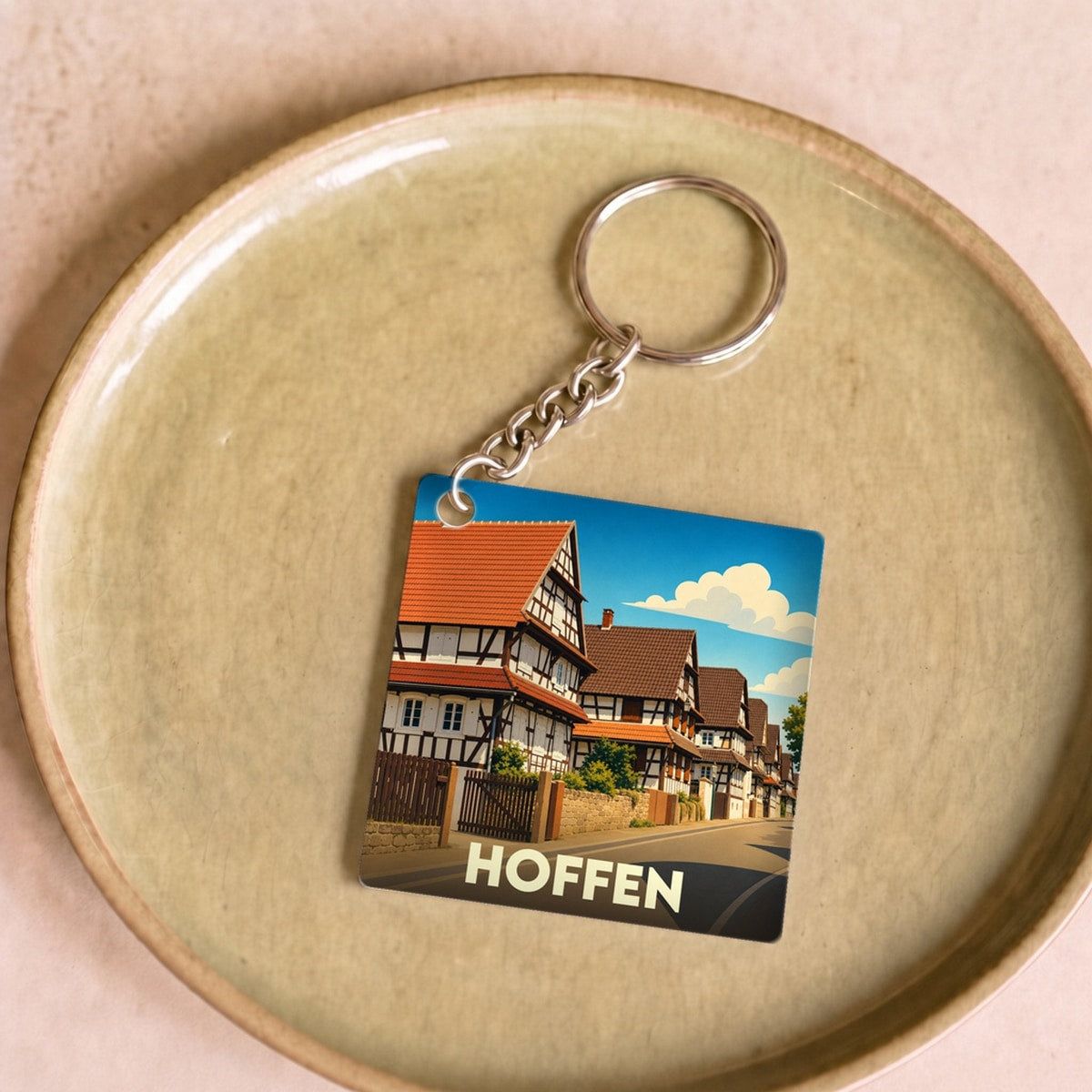 Porte-clés souvenir de la ville de Hoffen avec une illustration stylisée de maisons à colombages.