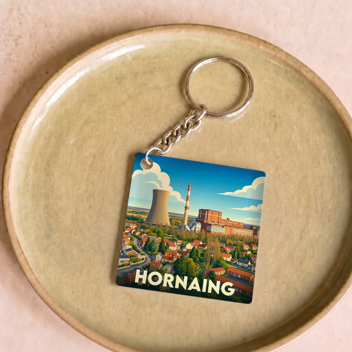 Porte-clés souvenir de la ville de Hornaing avec une illustration stylisée de sa centrale thermique.