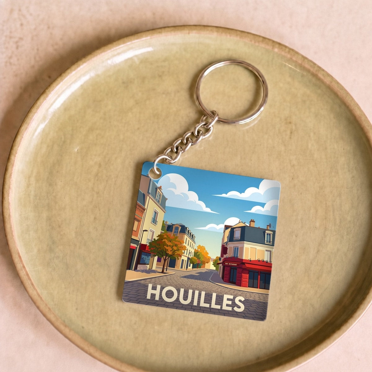 Porte-clés souvenir de la ville de Houilles avec une illustration stylisée.