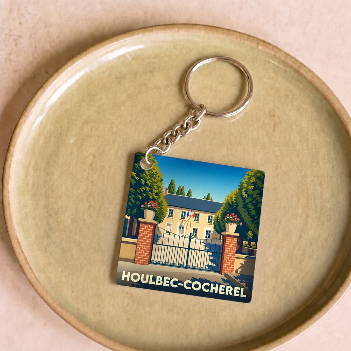 Porte-clés souvenir de la ville de Houlbec-Cocherel avec une illustration stylisée.