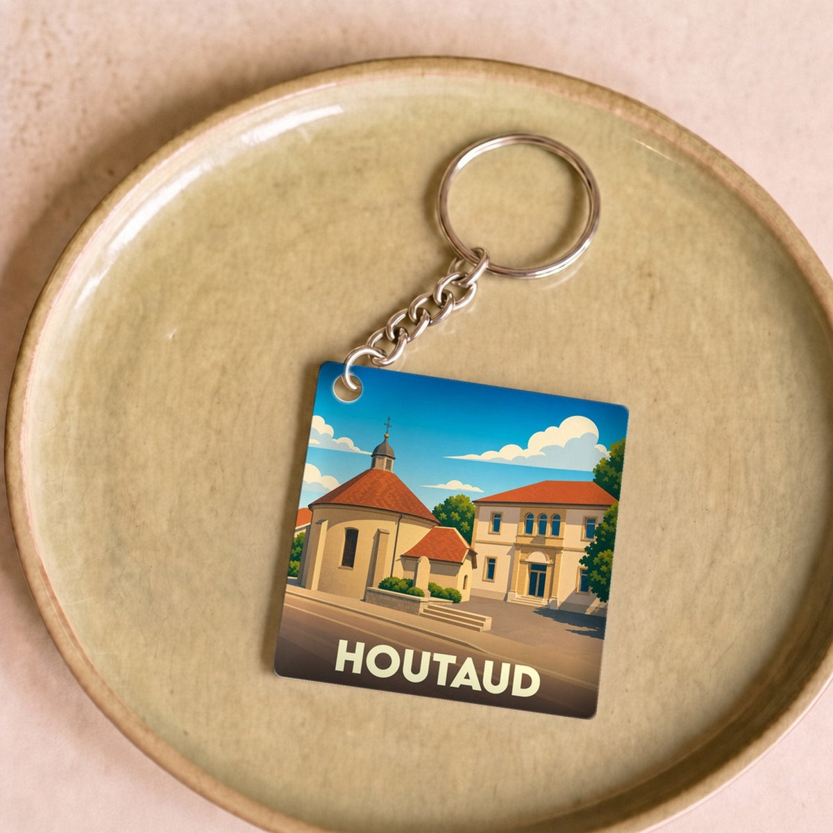 Porte-clés souvenir de la ville de Houtaud avec une illustration stylisée.