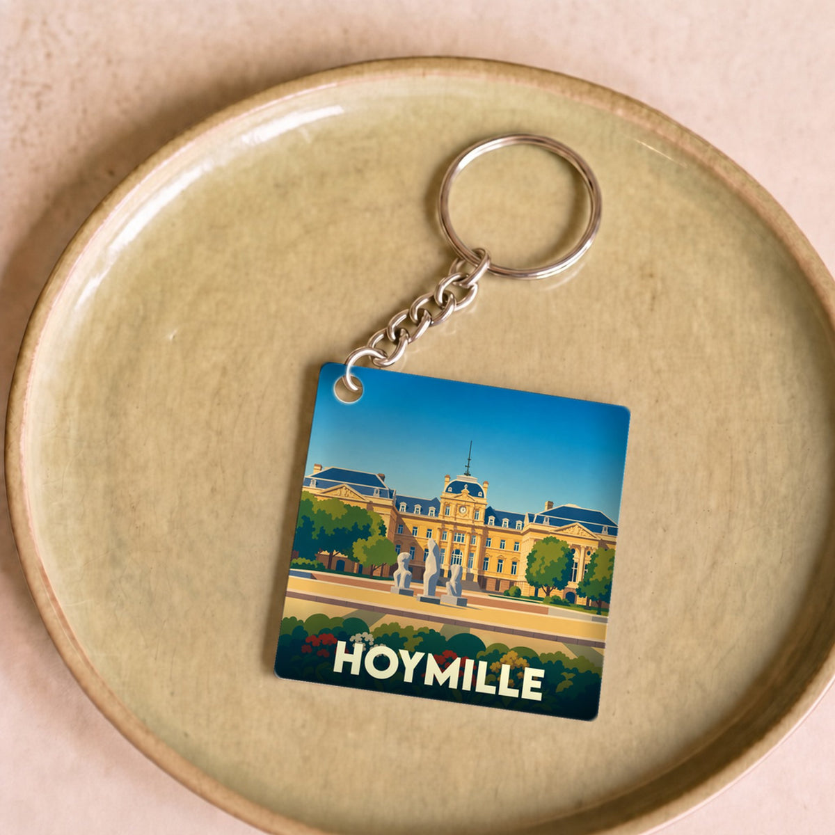 Porte-clés souvenir de la ville de Hoymille avec une illustration stylisée.