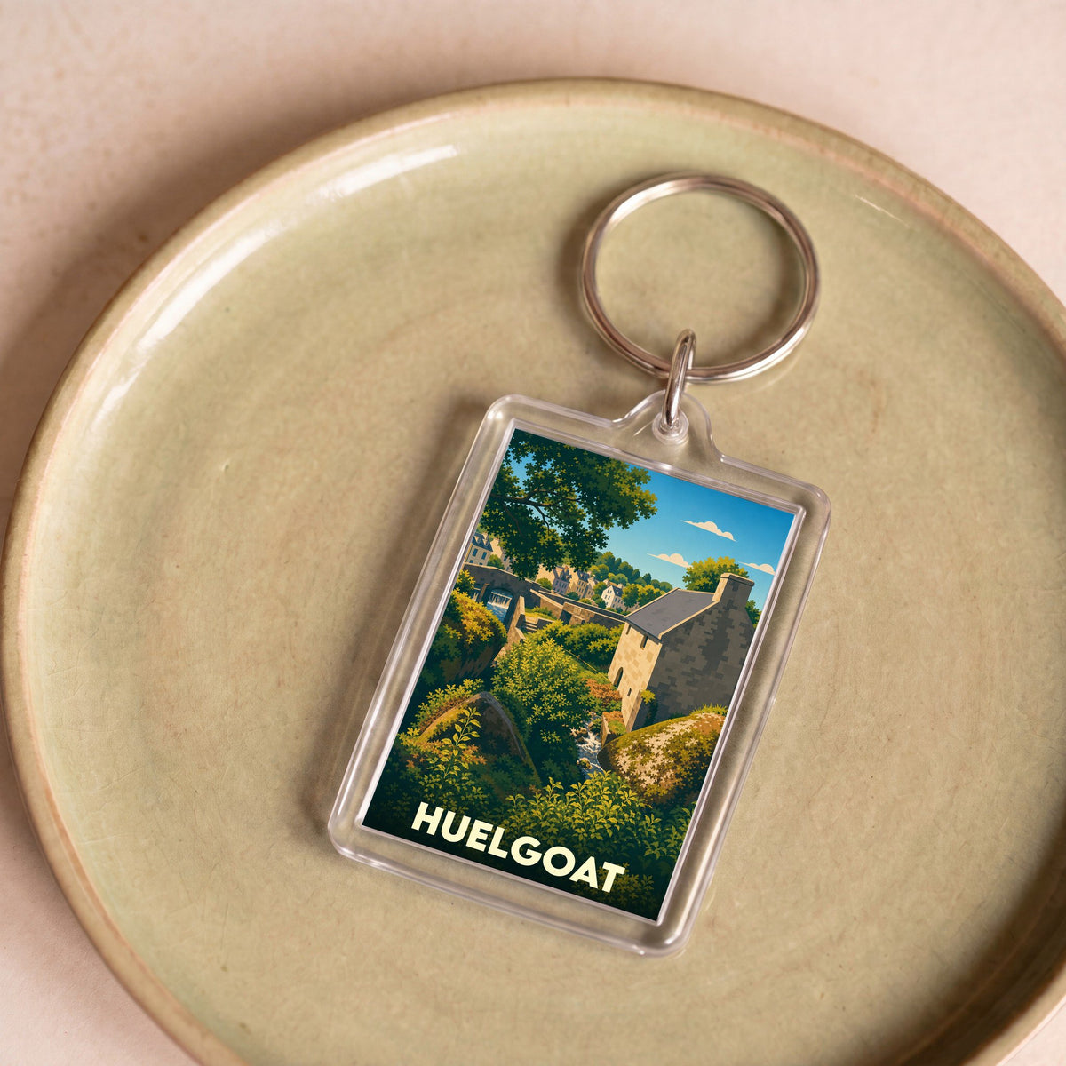 Porte-clés souvenir de la ville de Huelgoat avec une illustration stylisée d'un paysage breton.
