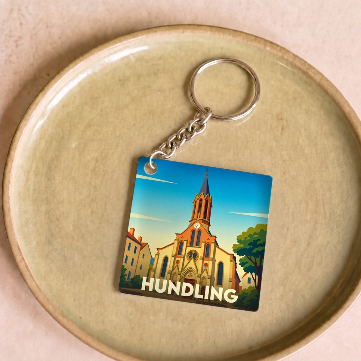 Porte-clés souvenir de la ville de Hundling avec une illustration stylisée de son église.