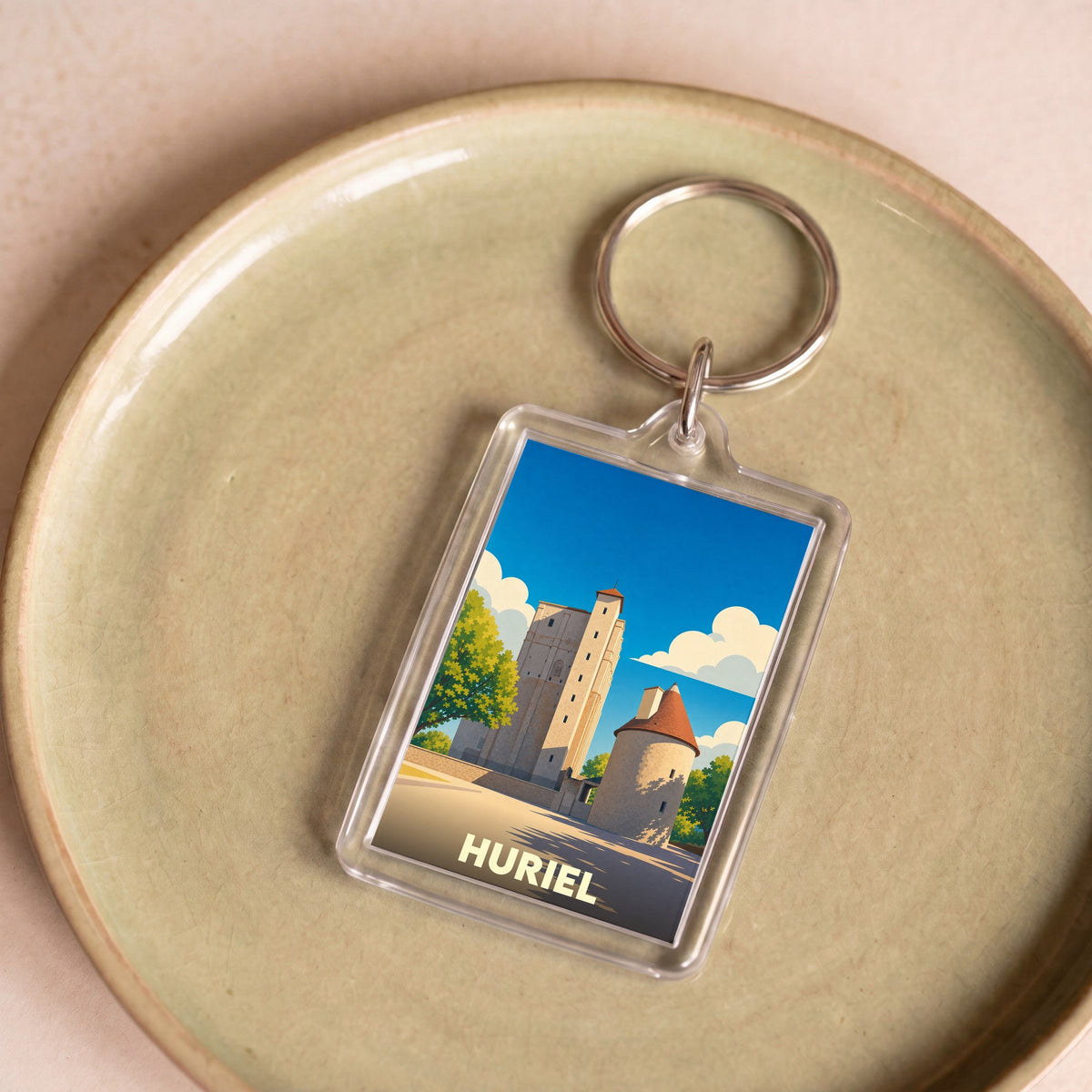 Porte-clés souvenir de la ville de Huriel avec une illustration stylisée.