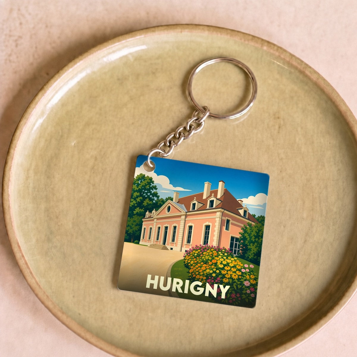 Porte-clés souvenir de la ville de Hurigny avec une illustration stylisée d'un château.