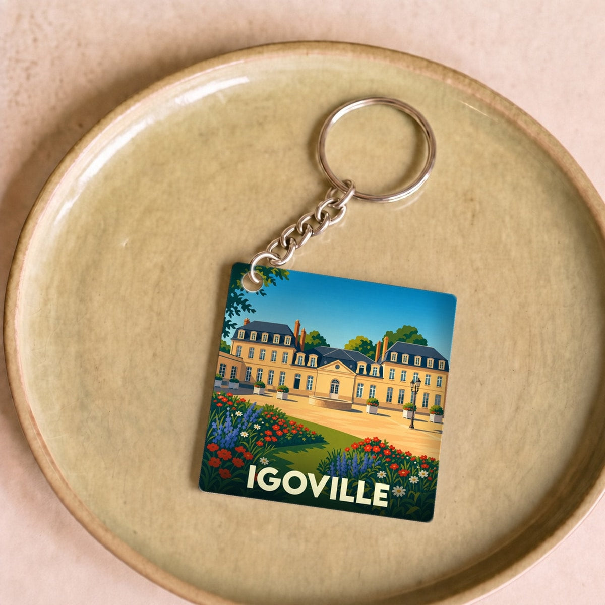 Porte-clés souvenir de la ville de Igoville avec une illustration stylisée d'un château fleuri.