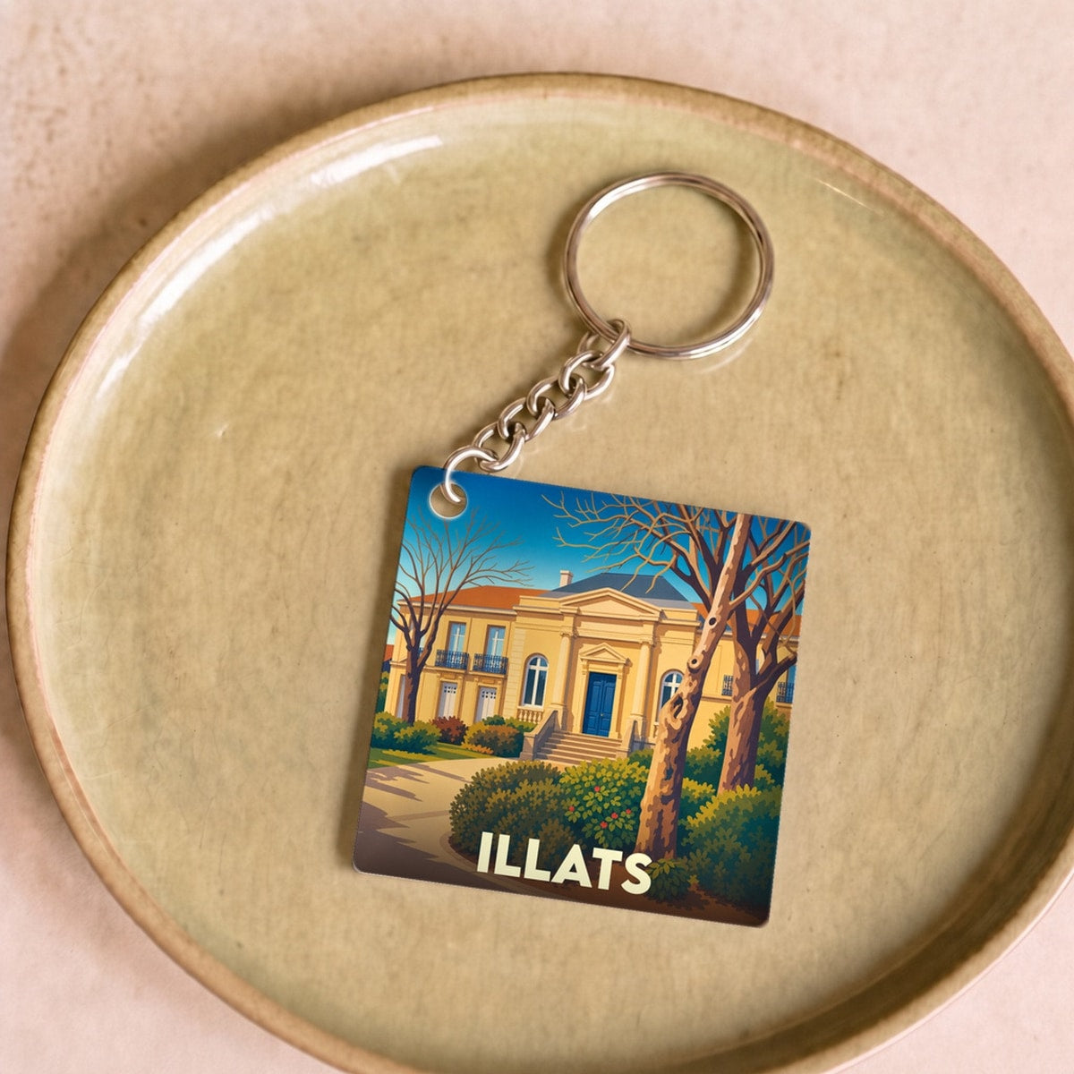 Porte-clés souvenir de la ville de Illats avec une illustration stylisée de sa mairie.