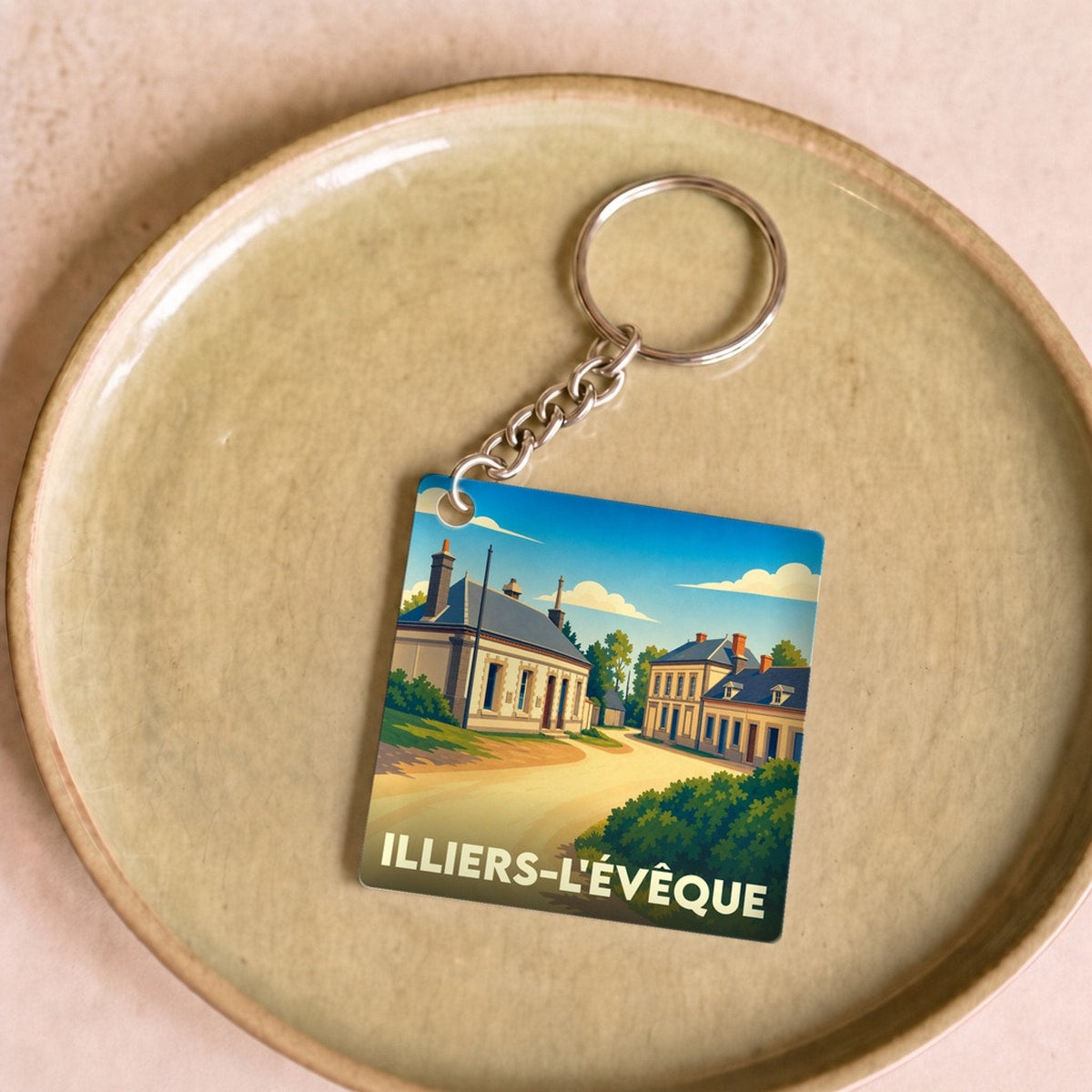 Porte-clés souvenir de la ville d'Illiers-l'Évêque avec une illustration stylisée.