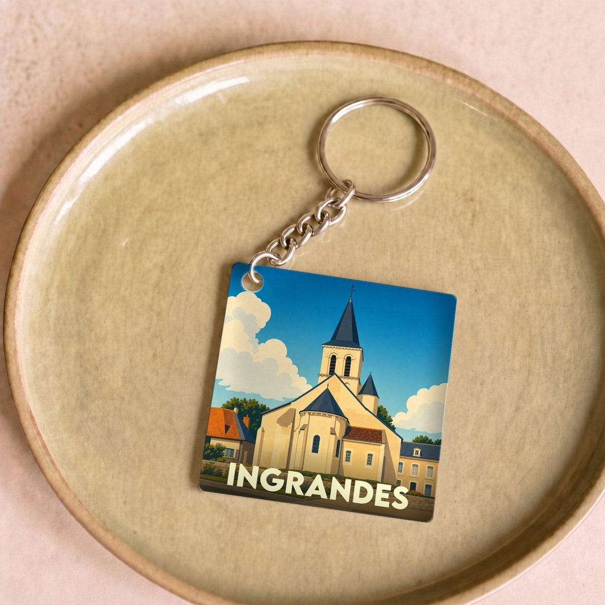 Porte-clés souvenir de la ville d'Ingrandes avec une illustration stylisée de son église.