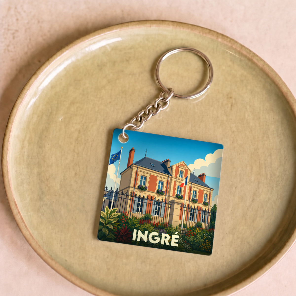 Porte-clés souvenir de la ville d'Ingré avec une illustration stylisée de la mairie.