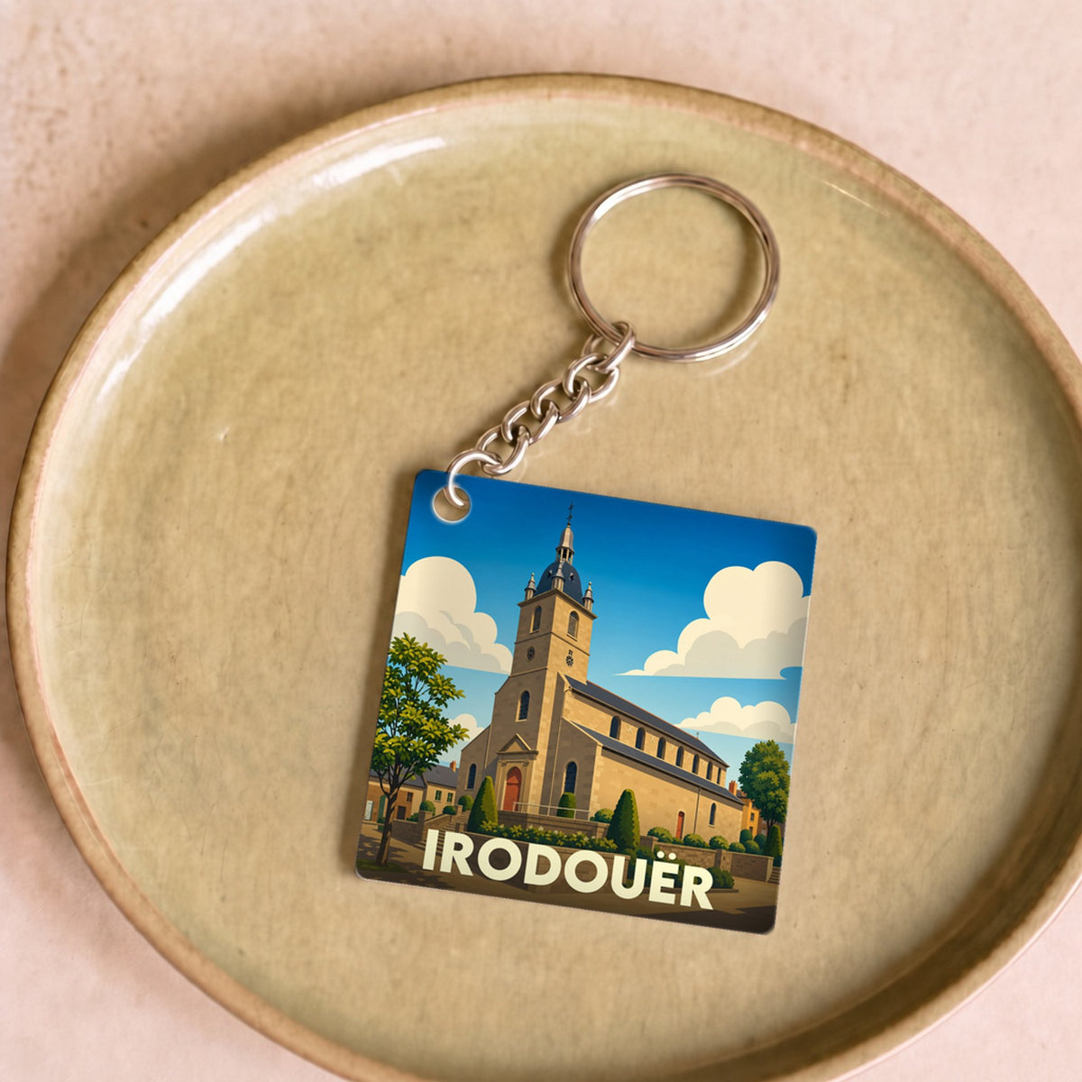 Porte-clés souvenir de la ville de Irodouër avec une illustration stylisée de son église.