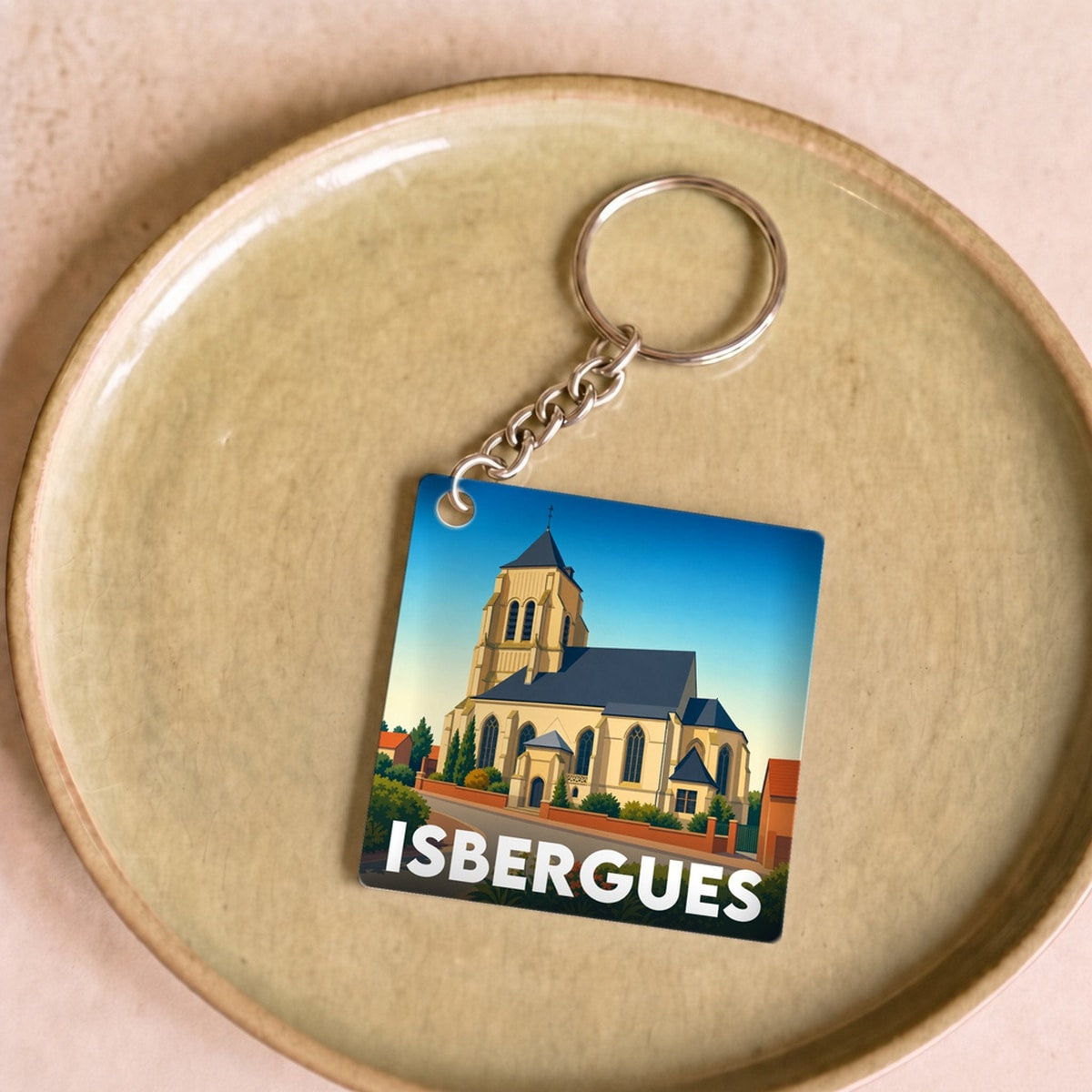 Porte-clés souvenir de la ville d'Isbergues avec une illustration stylisée de son église.