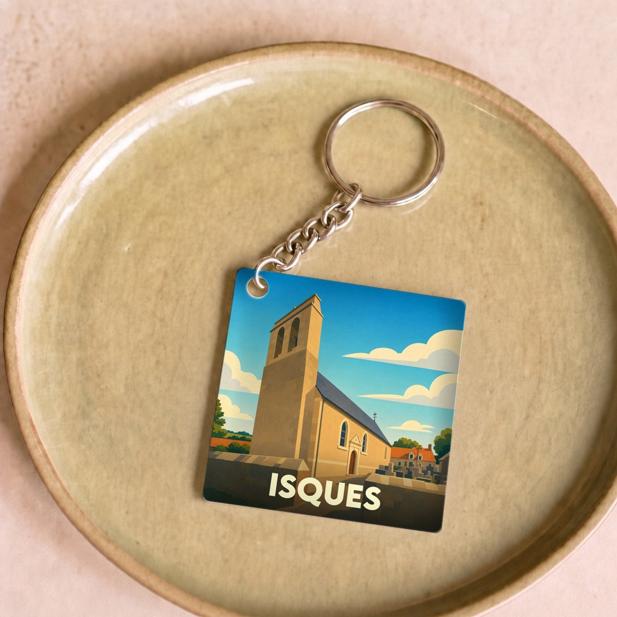 Porte-clés souvenir de la ville d'Isques avec une illustration stylisée de son église.