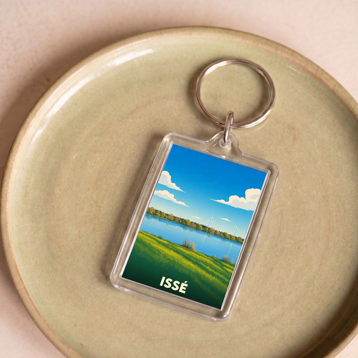Porte-clés souvenir de la ville de Issé avec une illustration stylisée de son paysage.
