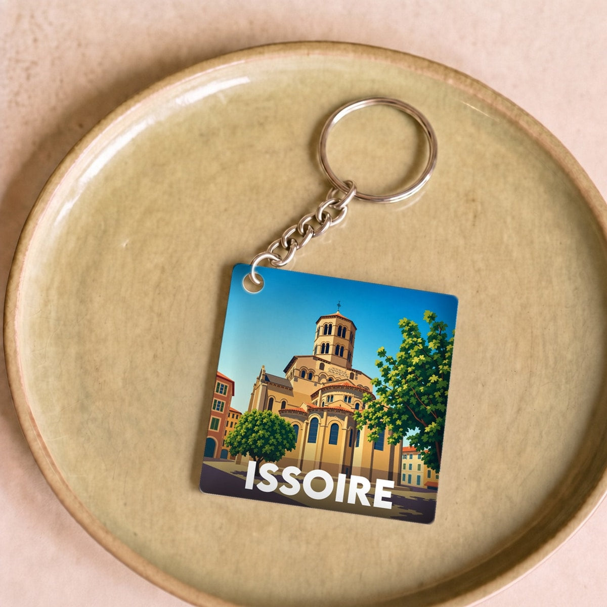 Porte-clés souvenir de la ville d'Issoire avec une illustration graphique stylisée.