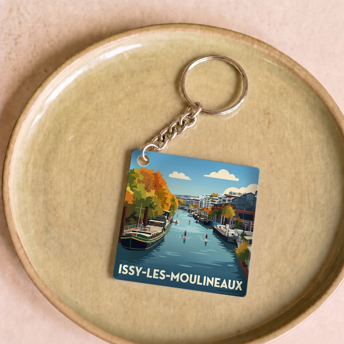 Porte-clés souvenir de la ville d'Issy-les-Moulineaux avec une illustration stylisée de ses bords de Seine.