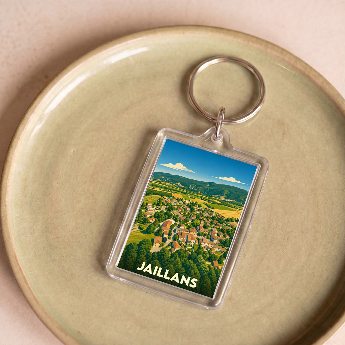 Porte-clés souvenir de la ville de Jaillans avec une illustration stylisée vue du ciel.