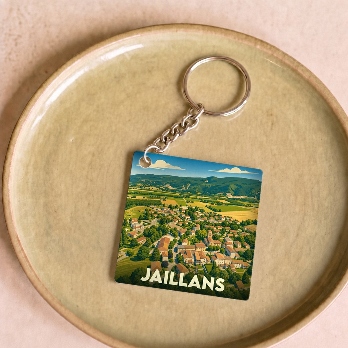 Porte-clés souvenir de la ville de Jaillans avec une illustration stylisée vue du ciel.