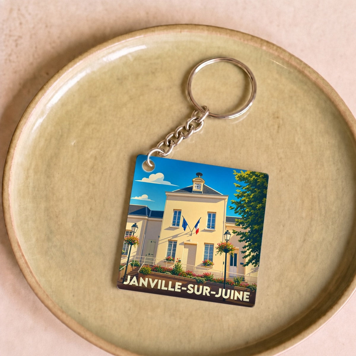 Porte-clés souvenir de la ville de Janville-sur-Juine avec une illustration stylisée de sa mairie.